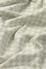 Detalle del punto de cuadros en azul salvia y natural de la manta Tiles.