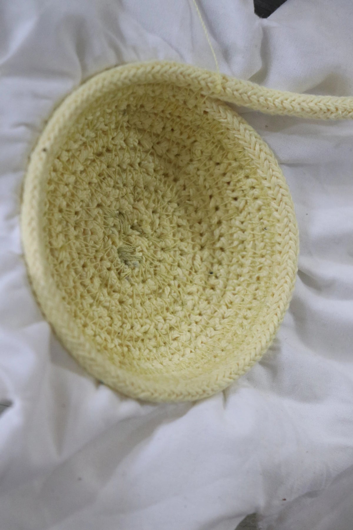 Detalle de la flor blanca de tela y su centro amarillo tejido del cojín Strawberry.