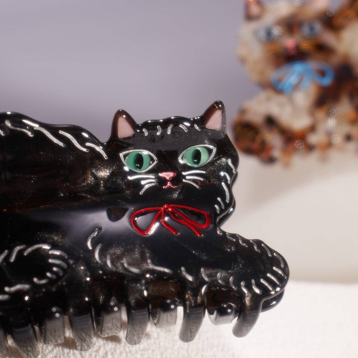 Pinza de pelo de gatito bonita y brillante de color negro con lazo rojo